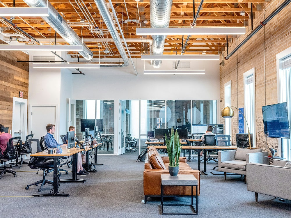 Open-plan hybrid office with desk zones, breakout seating and glass meeting room