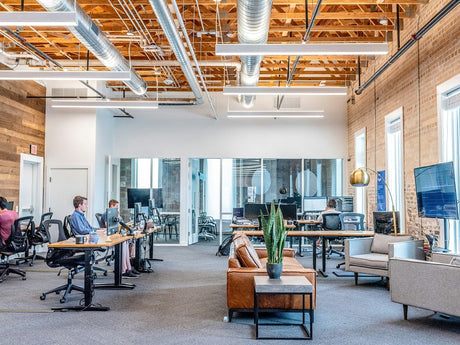 Open-plan hybrid office with desk zones, breakout seating and glass meeting room