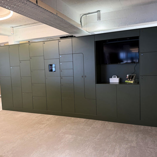 A storagewall combination unit comprised of smart lockers, TV and cupboards
